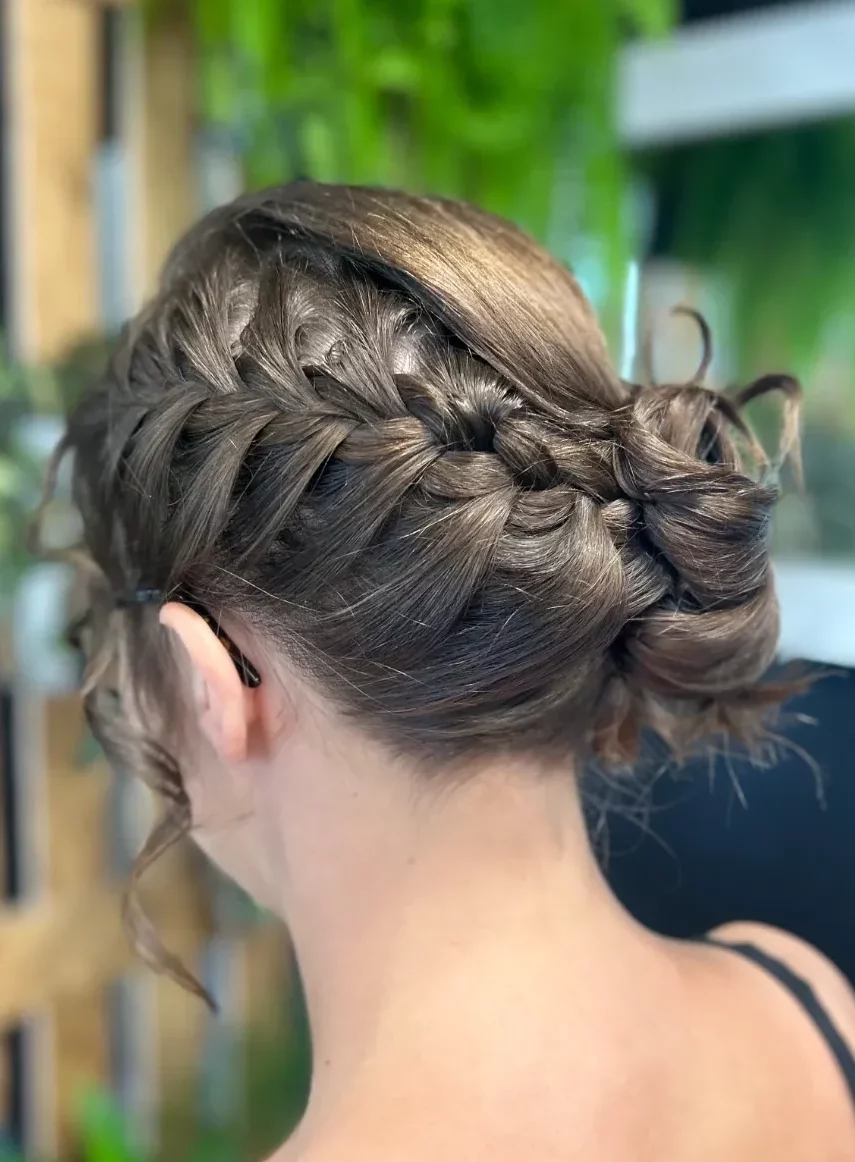 Chignon romantique avec tresses parfait pour un mariage.