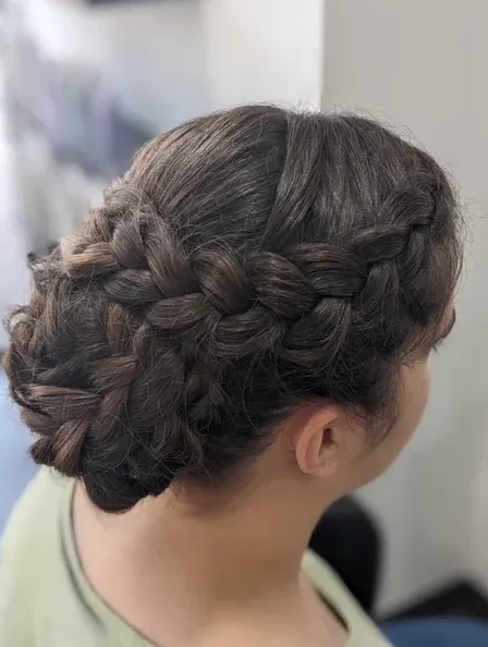 Chignon romantique avec tresses sur cheveux longs parfait pour un mariage.