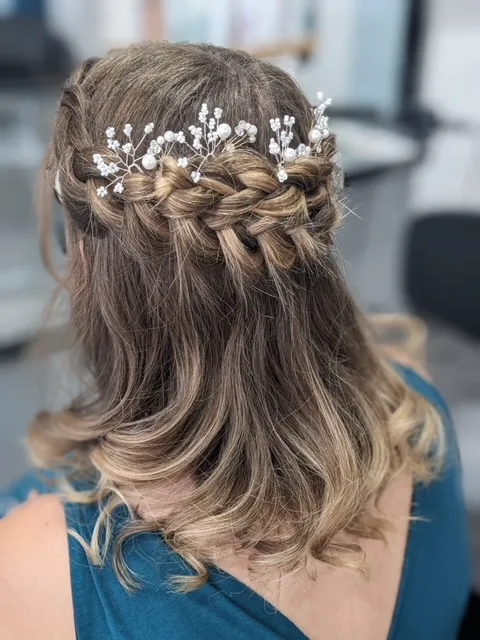 Tresse plate romantique avec bijou de cheveux parfaite pour un mariage.